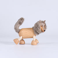 Wooden toy wolf with gray fur on a light gray background